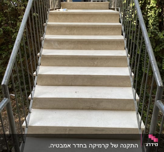 מדרגות שיש עם מעקה מתכת, בקבוק פלסטיק על המדרגה העליונה